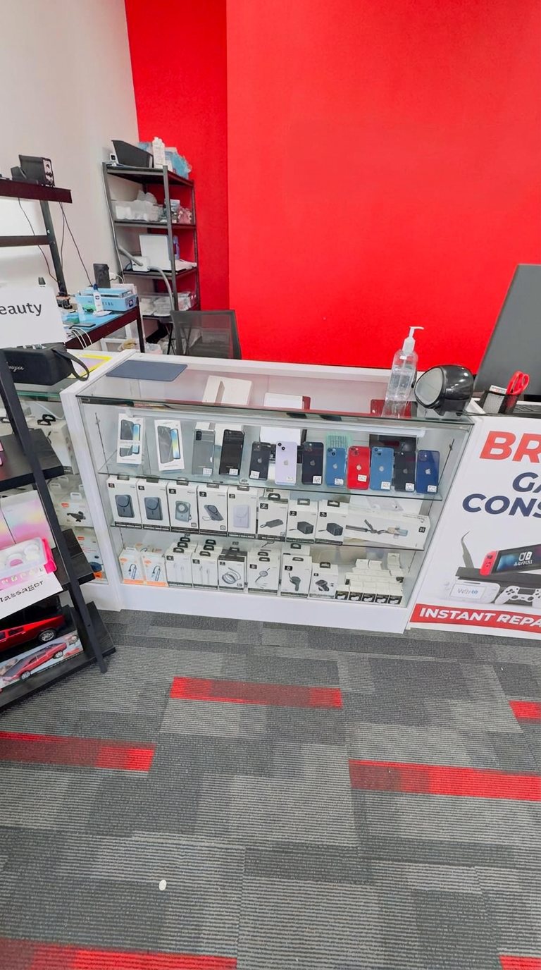 Glass display case of iPhones and accessories next to the repair bench